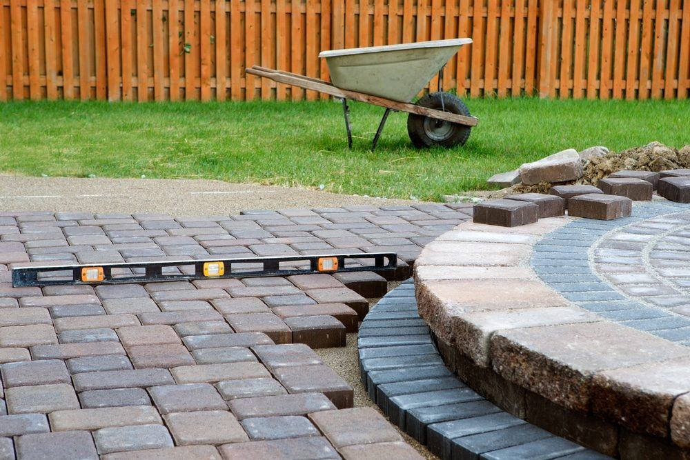 Pavers being laid around a circular patio feature