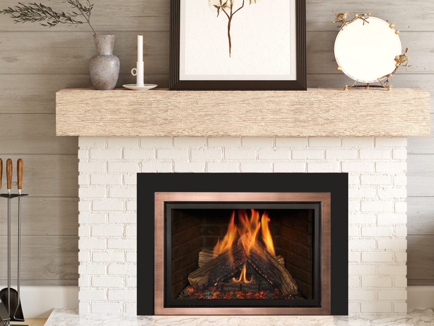 A Kozy Heat gas insert with a copper-toned frame and black surround burning inside a white painted brick fireplace under a wood beam mantel