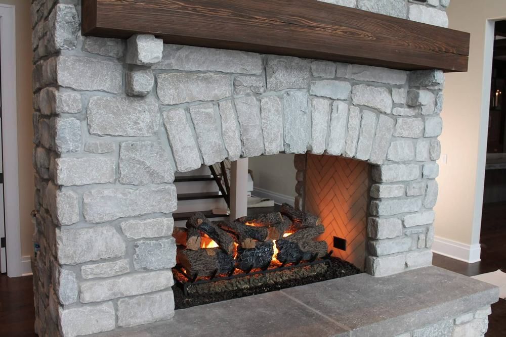 A lit gas fireplace set into a stone surround