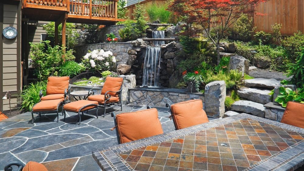 An outdoor fireplace and seating area on a paver patio