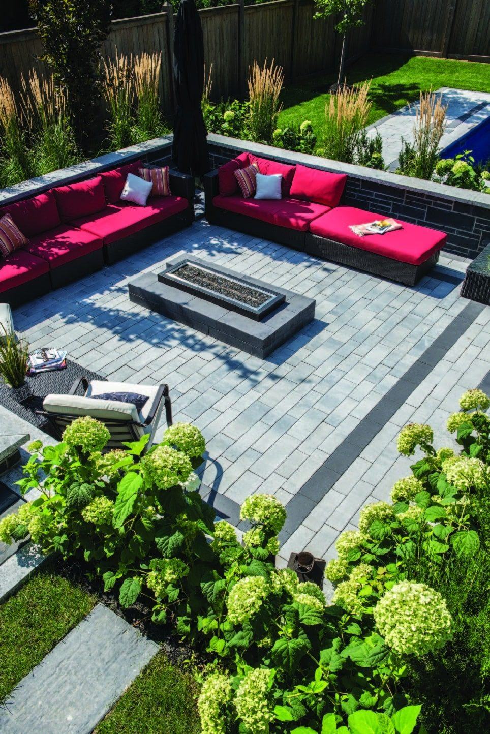 A paver patio seen from above, with outdoor seating around a fire table